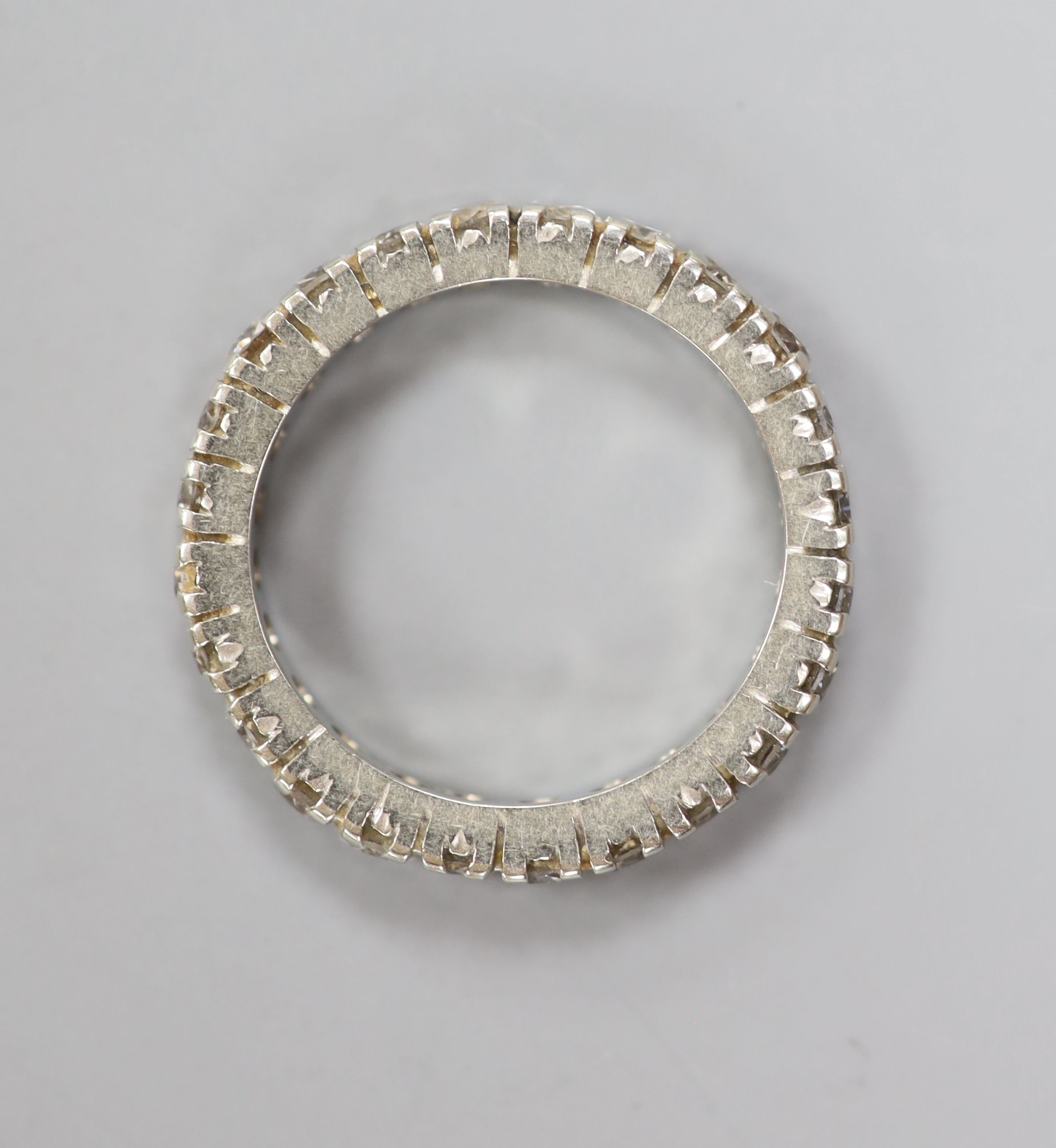 A 750 white metal and diamond set full eternity ring, set with twenty four round brilliant cut stones, size L/M,